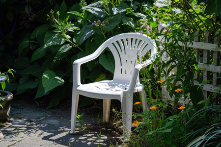 Biela záhradná stolička na záhrade.